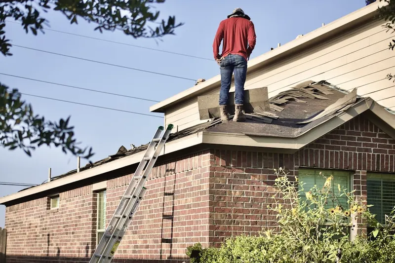 Professional roofer working on a residential roof in Old Avon Village